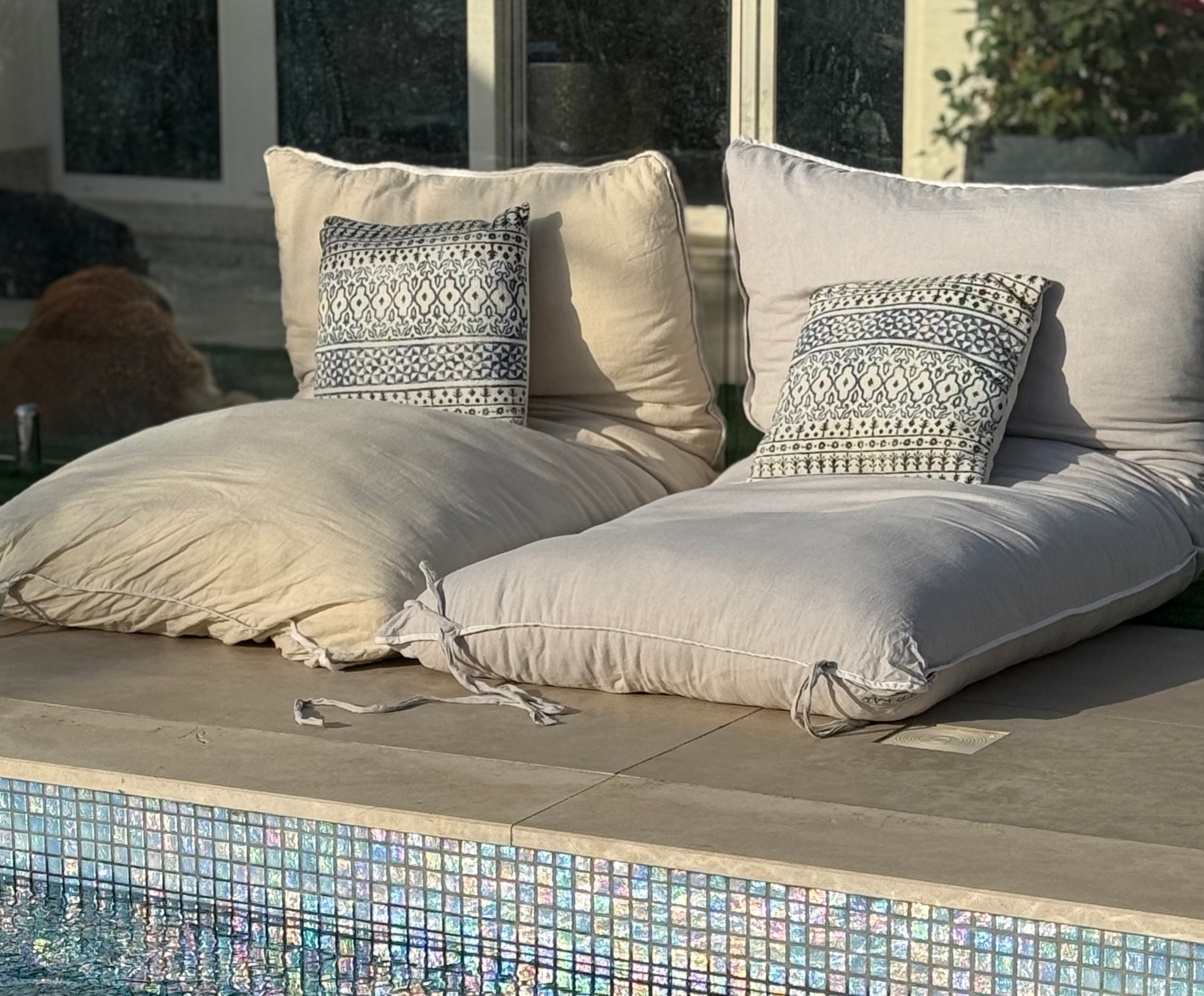 Outdoor seating area with cushions by a poolside